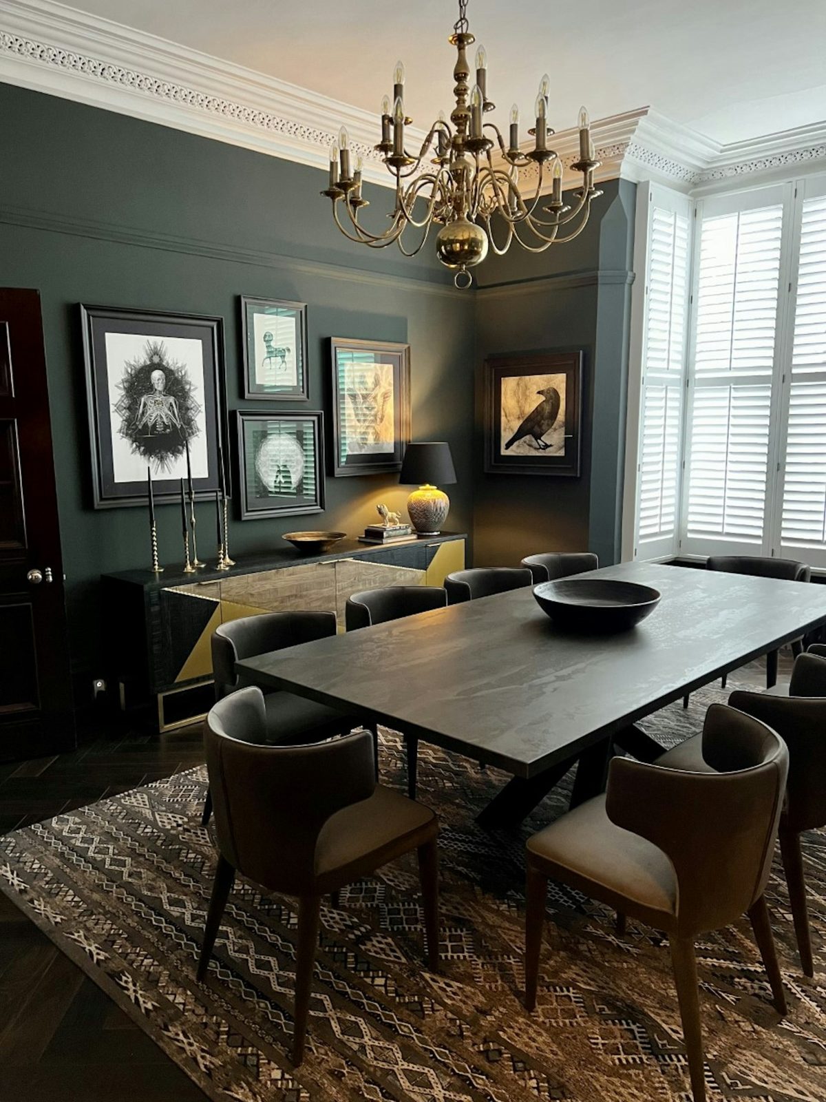A dark Dekton Radium dining table in a green dining room
