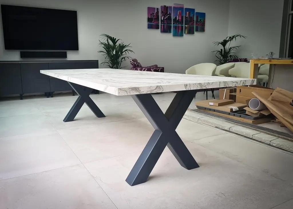 A white marble-look Dekton table on a black steel X base