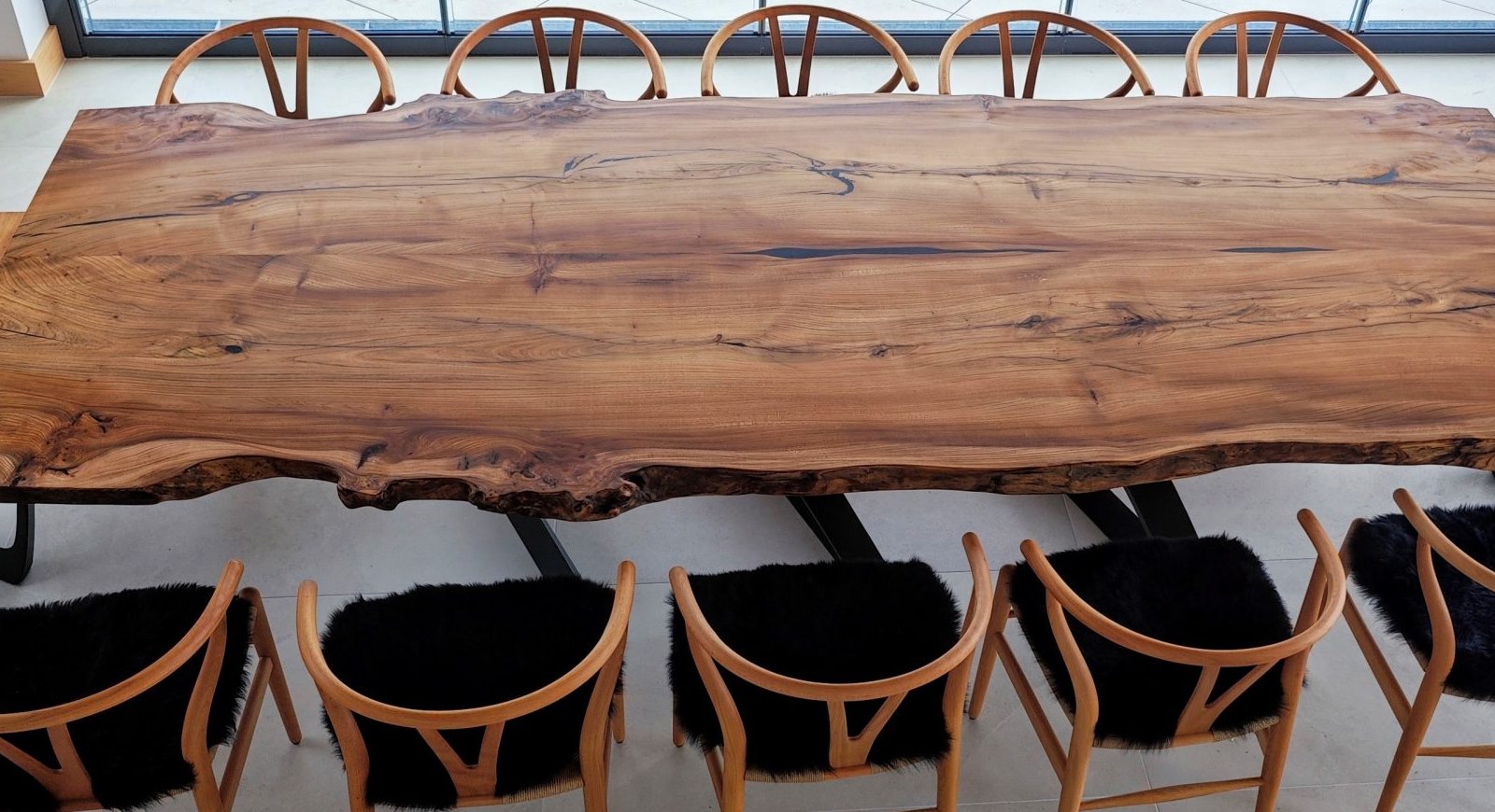 An English elm live-edge dining table with wishbone chairs, made by Sorrell & Smith