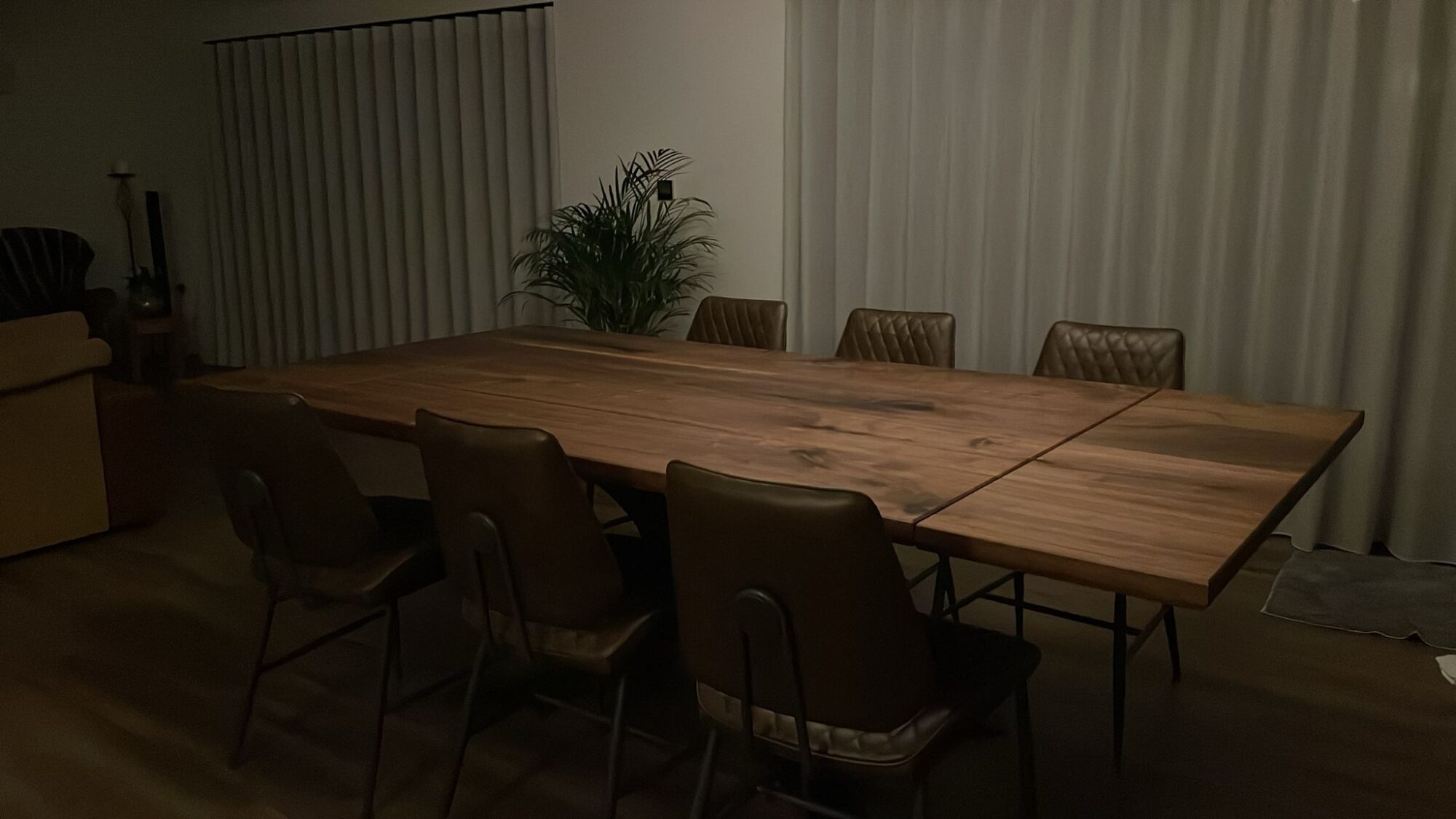 Walnut table in a dining room with leather chairs